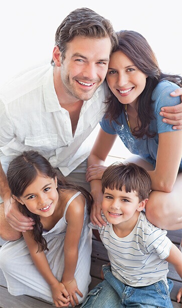 Family of four smiling in a photo