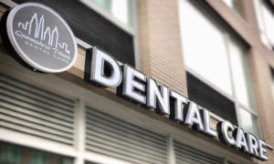 Closeup view of the exterior street sign of Queensboro Plaza Dental Care in Long Island City