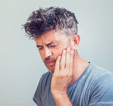 Man holding jaw in pain