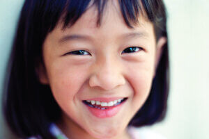 Closeup of a little Asian girl who has overcome her dental anxiety in Long Island City, NY