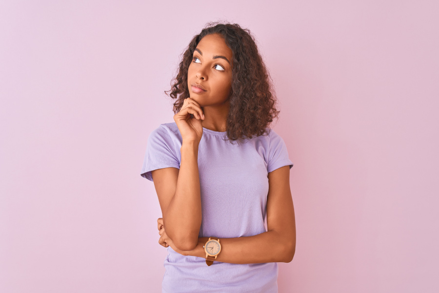 brunette woman in a lavender shirt wonders if pollution in New York affects her teeth and oral health