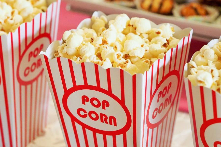 Red & white striped container filled with popcorn.