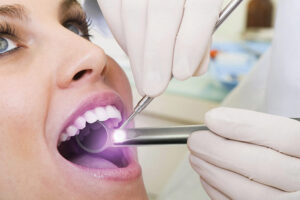 Woman getting an oral cancer screening.