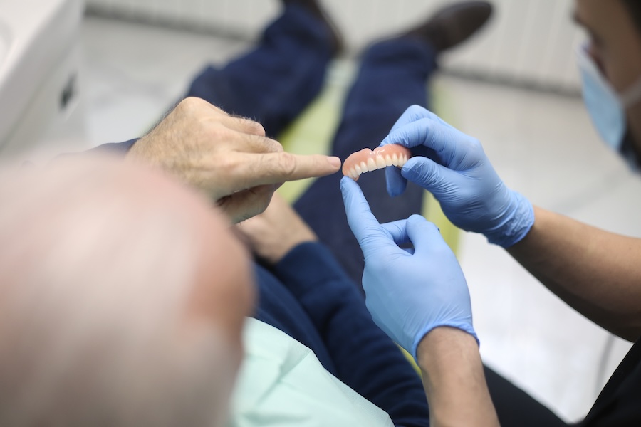 patient talking to dentist about replacing denture